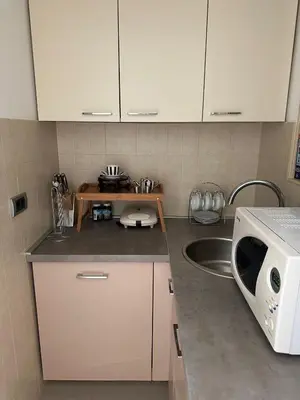 a kitchen with white cabinets and a sink and a microwave at VRACAR Apartment in Belgrade
