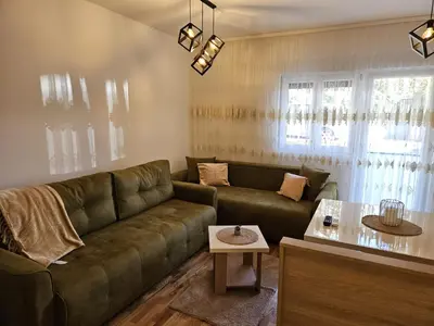 a living room with a green couch and a table at Apartman Meggy in Belgrade