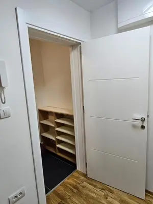 a closet with a white door and a shelf at Apartman Meggy in Belgrade