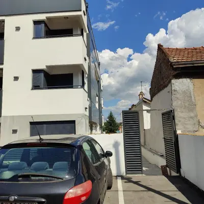 a car parked in a parking lot next to a building at Apartman Meggy in Belgrade