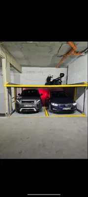 two cars are parked under a parking garage at Apartman Meggy in Belgrade