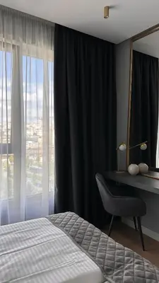 a bedroom with a bed and a desk and a window at DOM Boutique Apartments VERDE in Belgrade