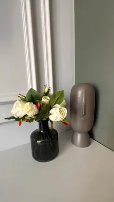 a vase with flowers in it on a table at DOM Boutique Apartments VERDE in Belgrade
