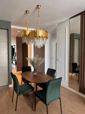 a dining room with a table and chairs and a chandelier at DOM Boutique Apartments VERDE in Belgrade