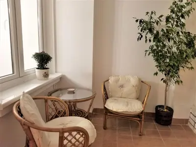 a room with two chairs and a table and a plant at Arena West Apartment in Novi Beograd