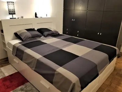 a black and white bed in a bedroom at Arena West Apartment in Novi Beograd