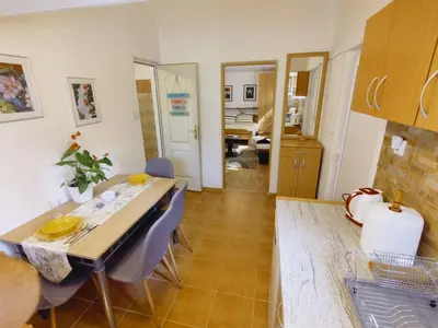 a kitchen and dining room with a table and chairs at Apartman Orhideja in Novi Banovci
