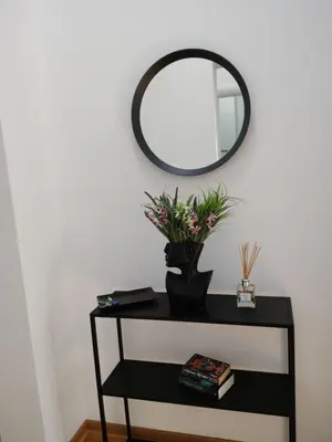 a black table with a mirror on a white wall at City011 in Belgrade