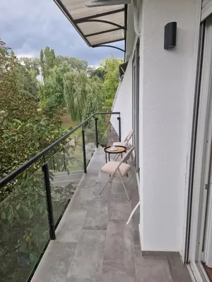 a balcony with a table and a chair on it at Royal apartment Sava river Blok 70 in Ada Ciganlija