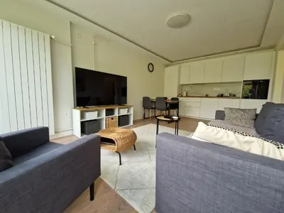 a living room with two couches and a flat screen tv at Royal apartment Sava river Blok 70 in Ada Ciganlija