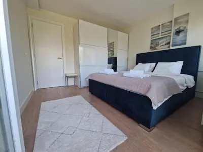 a bedroom with a large bed and a rug at Royal apartment Sava river Blok 70 in Ada Ciganlija