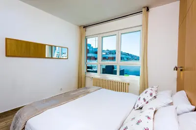 a bedroom with a bed and a large window at Arena Penthouse Apartments in Belgrade