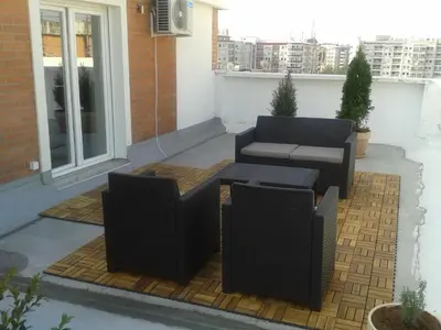 a patio with two chairs and a table on a balcony at Arena Penthouse Apartments in Belgrade