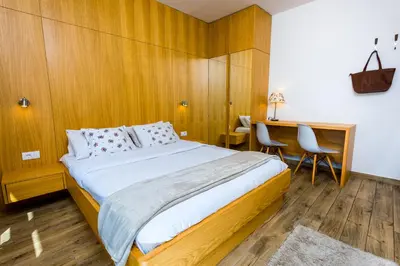 a bedroom with a bed and a desk and chairs at Arena Penthouse Apartments in Belgrade