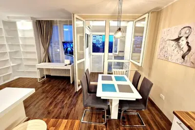 a dining room with a white table and chairs at Apartman Meri in Tošin Bunar