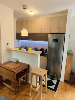 a kitchen with a stainless steel refrigerator and a table at Duplex Delight in Belgrade