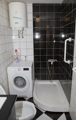 a bathroom with a toilet and a washing machine at Duplex Delight in Belgrade