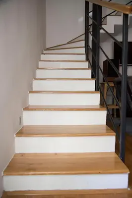 a staircase with white stairs and wooden floors at Duplex Delight in Belgrade