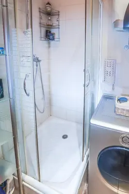 a shower with a sink and a washing machine at Tesla Museum Residence in Belgrade