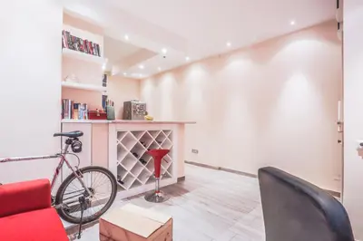 a bike in a living room with a red chair at Tesla Museum Residence in Belgrade