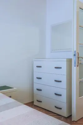 a bedroom with a white dresser and a drawer at Tesla Museum Residence in Belgrade