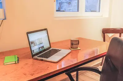 a laptop computer sitting on top of a wooden desk at Tesla Museum Residence in Belgrade