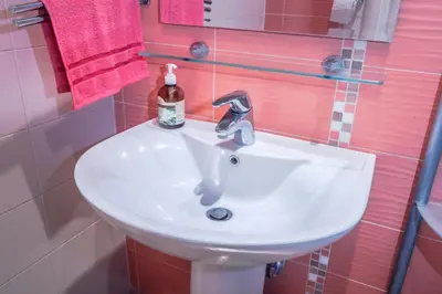 a bathroom sink with a bottle of soap on it at Tesla Museum Residence in Belgrade