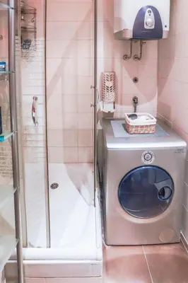 a washing machine in a bathroom with a shower at Tesla Museum Residence in Belgrade