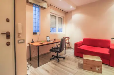 a room with a desk and a red couch at Tesla Museum Residence in Belgrade