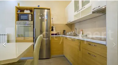a kitchen with a stainless steel refrigerator and wooden cabinets at Central Garden modern 1 bedroom condominium complex in Belgrade