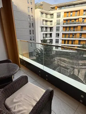 a balcony with two chairs and a view of a building at Central Garden modern 1 bedroom condominium complex in Belgrade