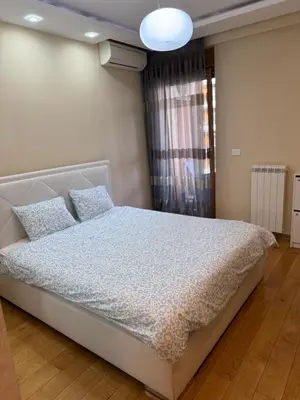 a bedroom with a white bed with blue comforter at Central Garden modern 1 bedroom condominium complex in Belgrade