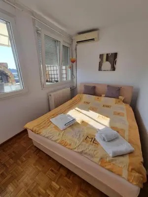 a bedroom with a large bed with two towels on it at Ušće apartman in Novi Beograd