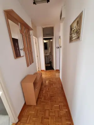 a hallway with a room with white walls and wooden floors at Ušće apartman in Novi Beograd