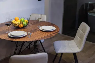 a wooden table with a bowl of fruit and wine glasses at Apartment Knez Belgrade in Belgrade