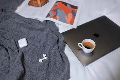 a laptop and a cup of coffee on a bed at Apartment Knez Belgrade in Belgrade