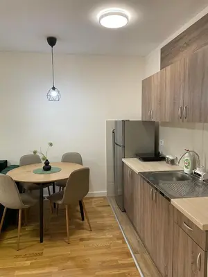 a kitchen with a table and a table and chairs at Cvetanov trg LUX 3 in Belgrade