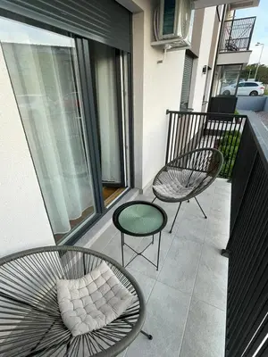 a balcony with two chairs and a green table and chairs at Cvetanov trg LUX 3 in Belgrade