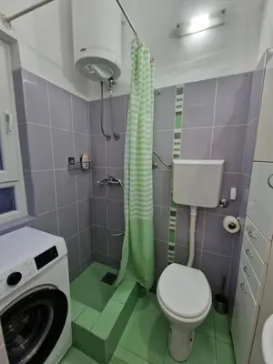 a bathroom with a toilet and a washing machine at Belgrade City Center Apartment in Belgrade