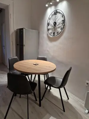 a table with chairs and a clock on a wall at Belgrade City Center Apartment in Belgrade