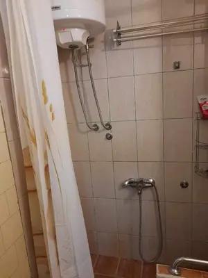 a shower in a bathroom with a shower curtain at Sobe Aerodrom in Surčin