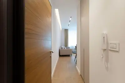 a wooden door leading into a hallway with a chair at Olive Apartments in Belgrade