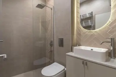 a bathroom with a sink and a toilet and a mirror at Olive Apartments in Belgrade