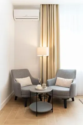 a living room with two chairs and a table at Olive Apartments in Belgrade