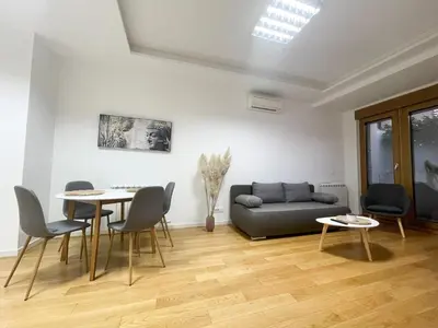 a living room with a couch and a table and chairs at Hedonist-Modern Urban Stay A Blok in Belgrade