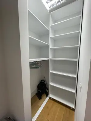 a walk in closet with white shelves at Hedonist-Modern Urban Stay A Blok in Belgrade