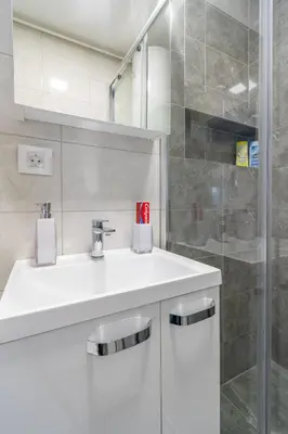 a bathroom with a white sink and a shower at Apartman Ivana in Novi Beograd