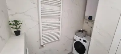 a white bathroom with a washing machine and a window at New luxury suite near St Sava Temple with garage in Belgrade