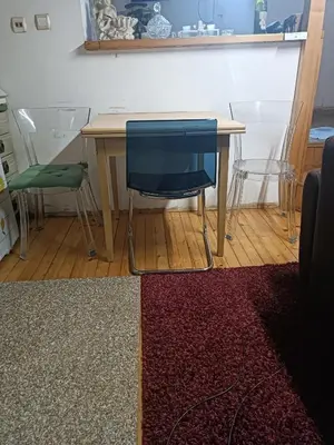 a table with a blue chair and a table with a rug at Maravilja in Filmski Grad