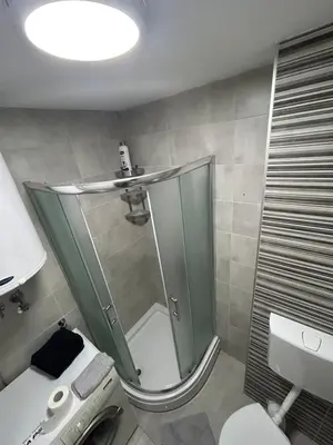 a bathroom with a shower and a toilet and a sink at Delete 44 in Novi Grad
